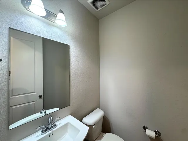 a bathroom with a sink mirror and toilet