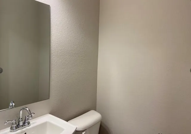 a white toilet sitting next to a bathroom sink