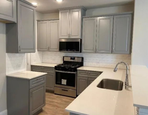 a kitchen with stainless steel appliances kitchen island granite countertop a refrigerator and a sink