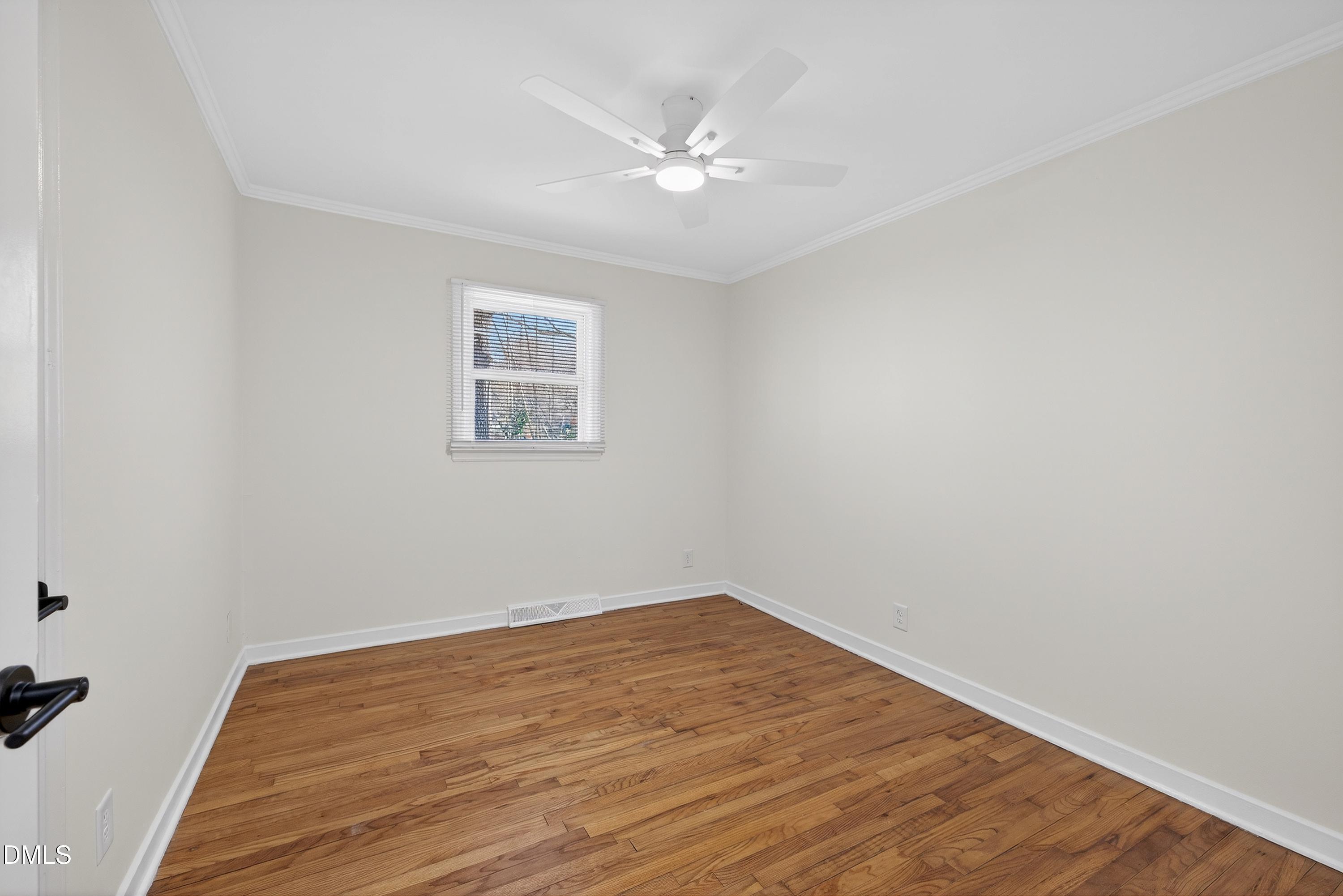 302 Normandy Street Durham, NC 27707 - Photo 19 of 29 a view of a room with wooden floor and a ceiling fan