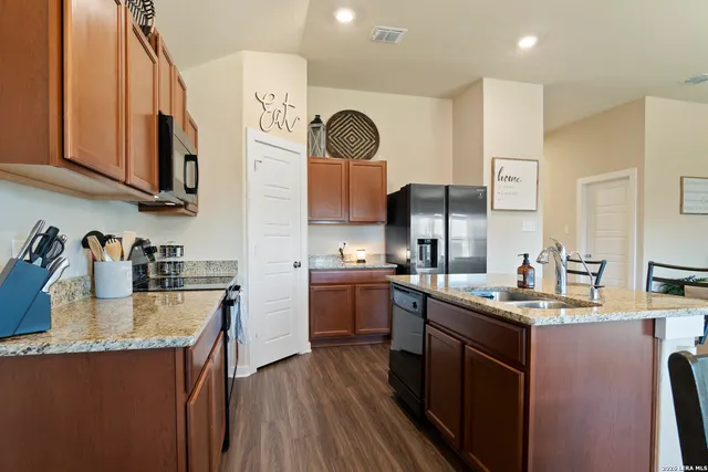 a kitchen with stainless steel appliances granite countertop a sink stove and refrigerator