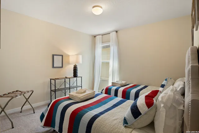 a bedroom with two beds and a lamp