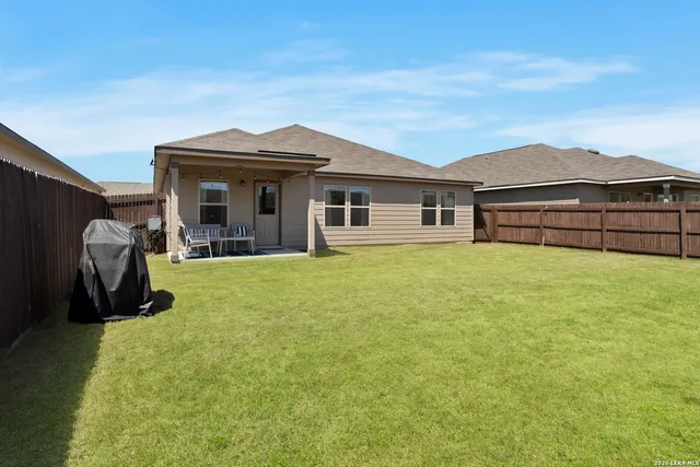 a view of a house with a backyard and a patio