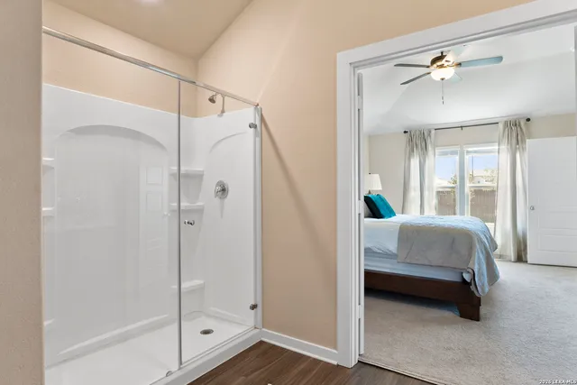 a en suite bathroom with a tub shower and mirror