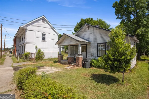 a view of a house with backyard and sitting area
