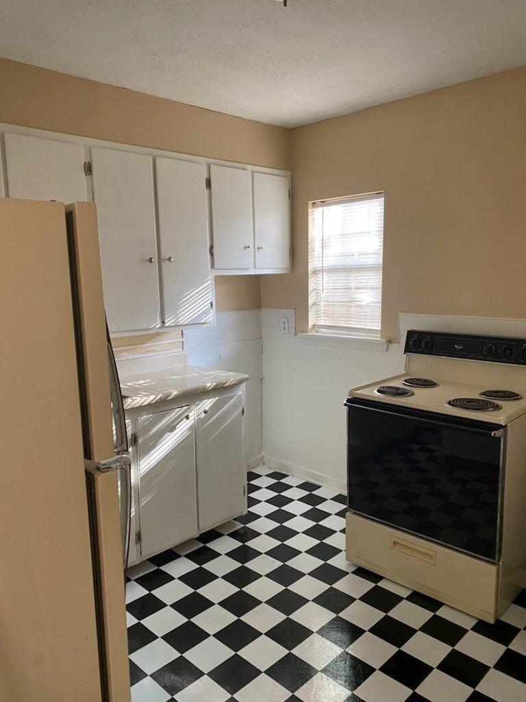 1109 45th Street, Unit B Lubbock, TX 79412 - Photo 4 of 4 a kitchen with a stove a sink and a refrigerator