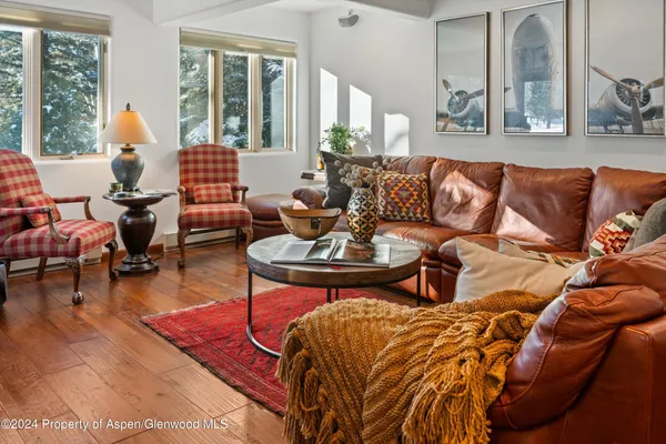 a living room with furniture and floor to ceiling windows