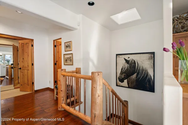a view of a hallway with wooden floor and closet