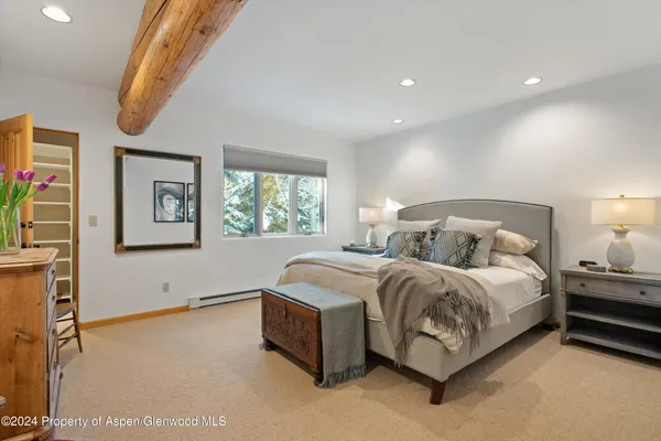 a spacious bedroom with a bed and a large window