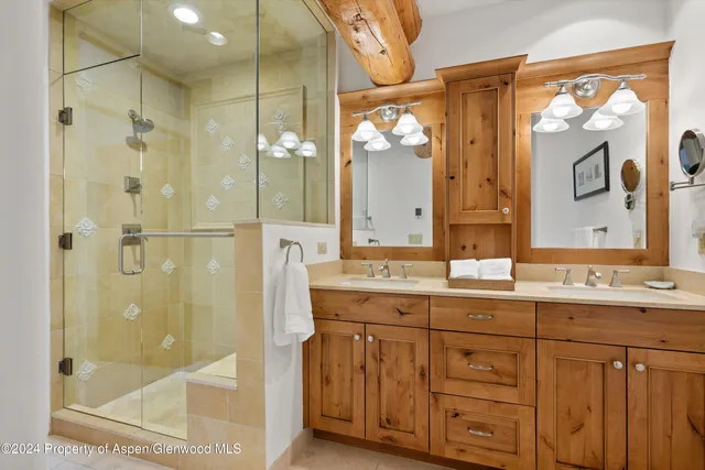 a bathroom with a granite countertop sink mirror and a shower