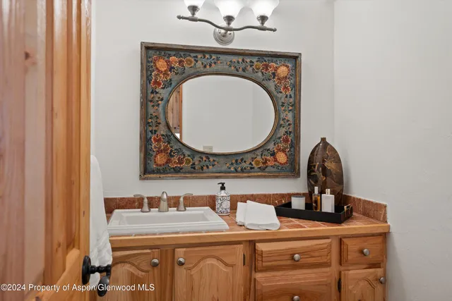 a bathroom with a granite countertop sink a mirror and vanity