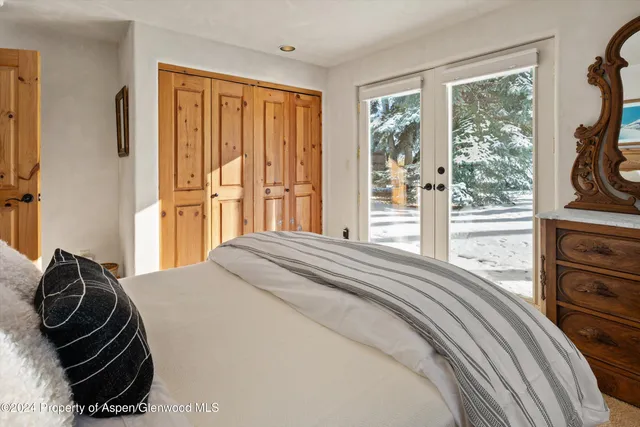 a bedroom with a bed and a dresser next to a window