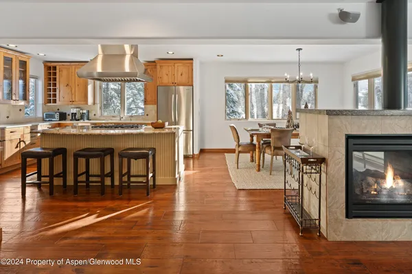 a dining room with furniture a fireplace and wooden floor