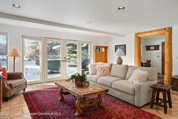 a living room with furniture a rug and a large window