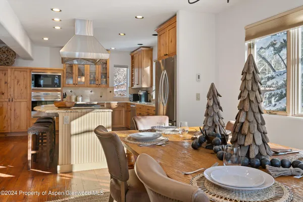 a dining room with stainless steel appliances a dining table and chairs