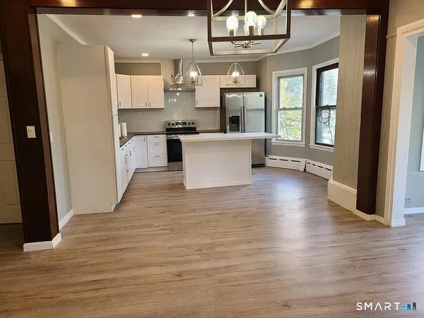 a view of kitchen and kitchen with granite countertop wooden floor