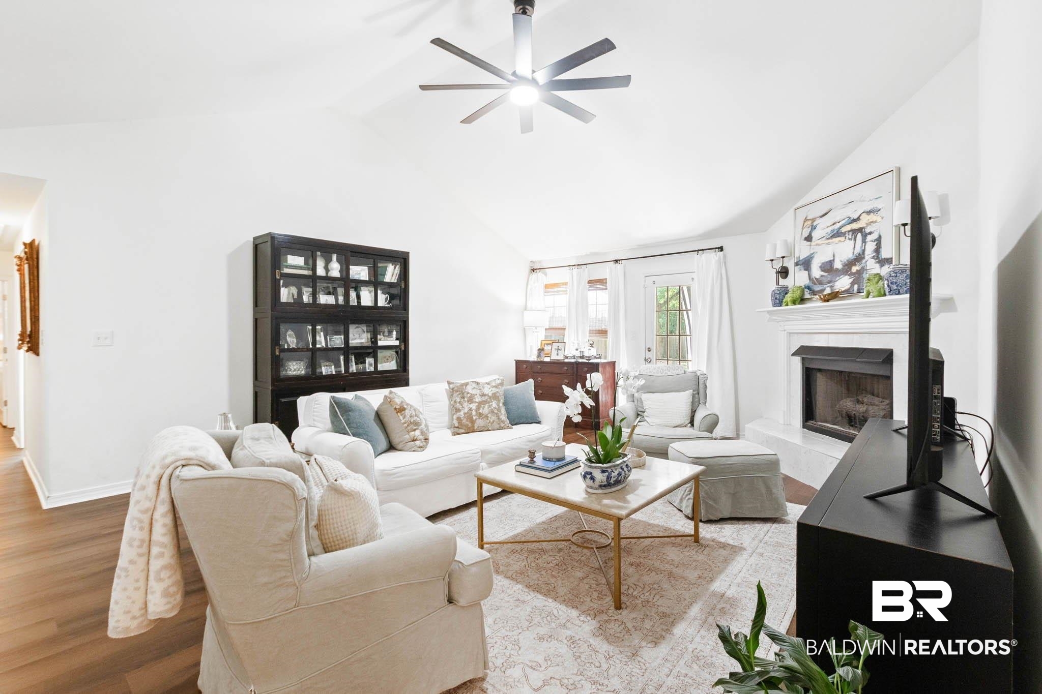 20685 Lowry Drive Fairhope, AL 36532 - Photo 12 of 48 Living room featuring light wood-style floors, a fireplace with raised hearth, ceiling fan, and high vaulted ceiling