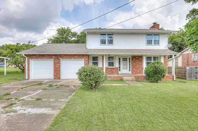 a front view of a house with a yard and potted plants