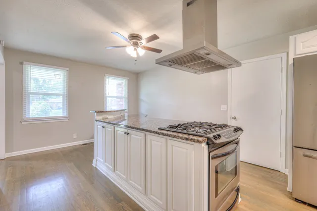 a kitchen with stainless steel appliances granite countertop a stove and a refrigerator