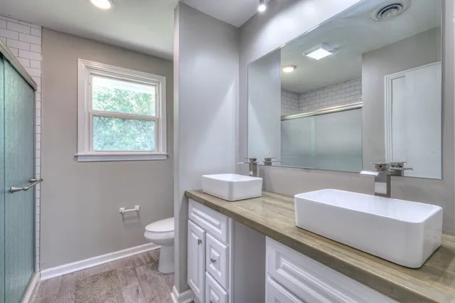 a bathroom with a granite countertop sink a toilet and a mirror
