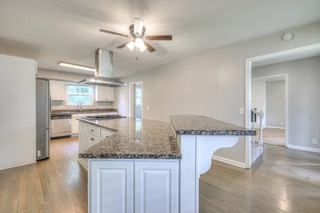 a kitchen with kitchen island granite countertop a table and chairs in it