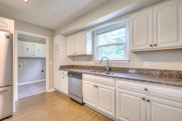 a kitchen with granite countertop white cabinets white appliances and a granite counter tops