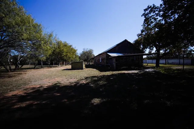 a view of a yard with wooden fence