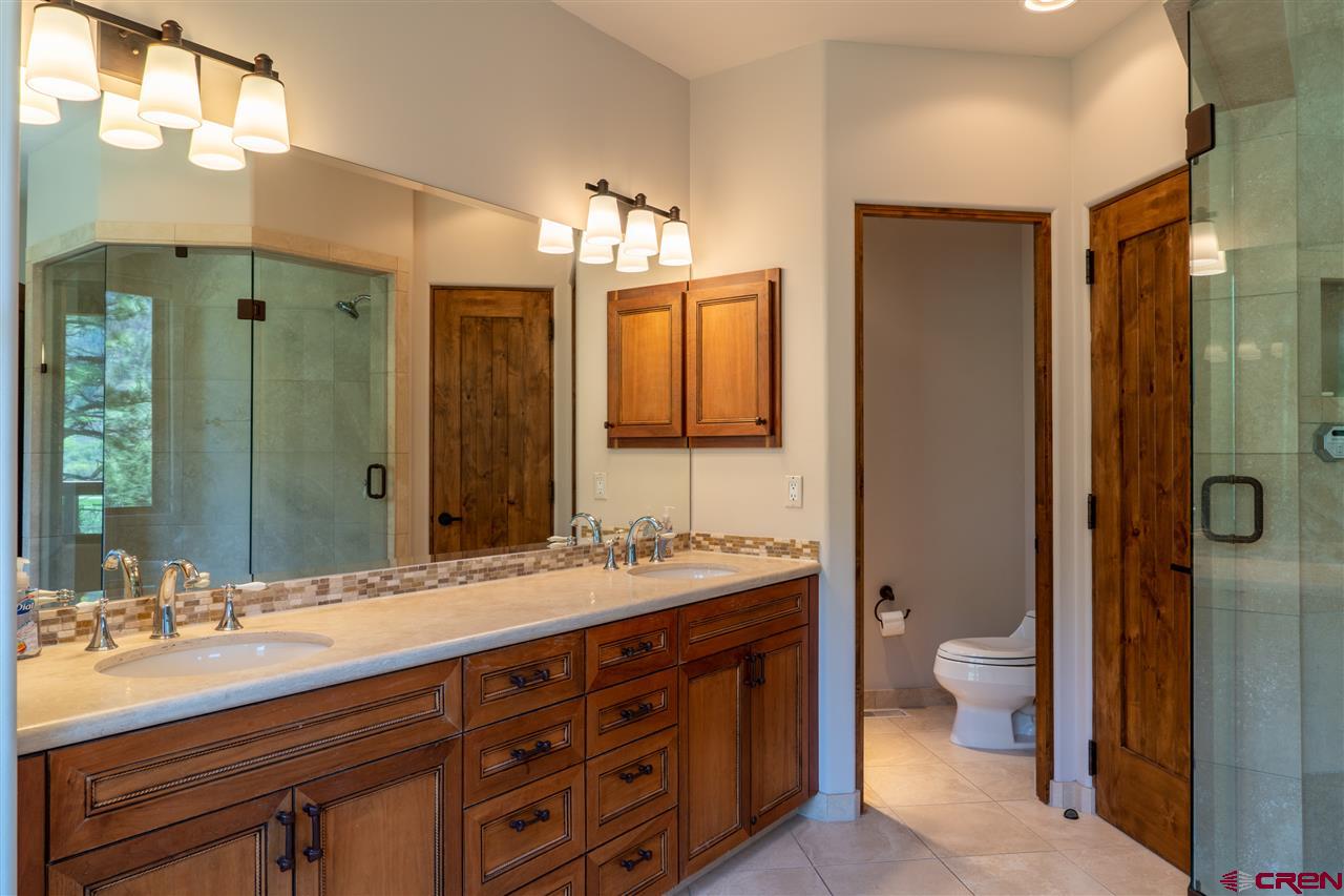 258 Goulding Creek Road Durango, CO 81301 - Photo 16 of 35 a bathroom with a double vanity sink a toilet and a mirror