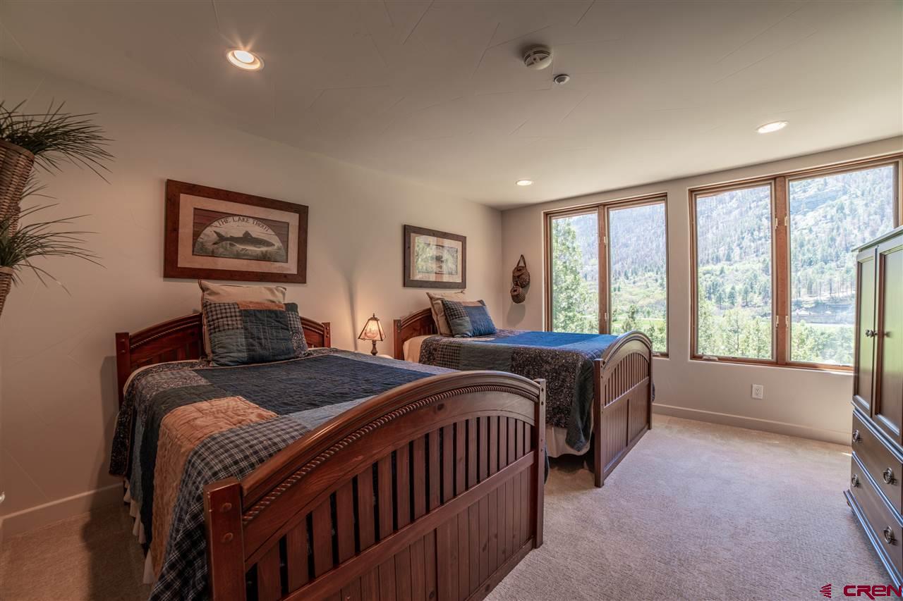 258 Goulding Creek Road Durango, CO 81301 - Photo 22 of 35 a bedroom with two beds and a large window