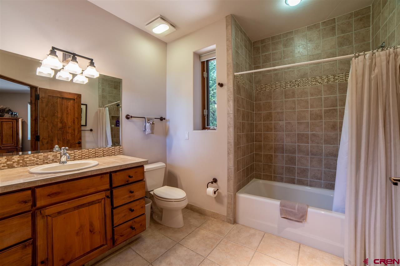 258 Goulding Creek Road Durango, CO 81301 - Photo 23 of 35 a bathroom with a double vanity sink a toilet a mirror and shower