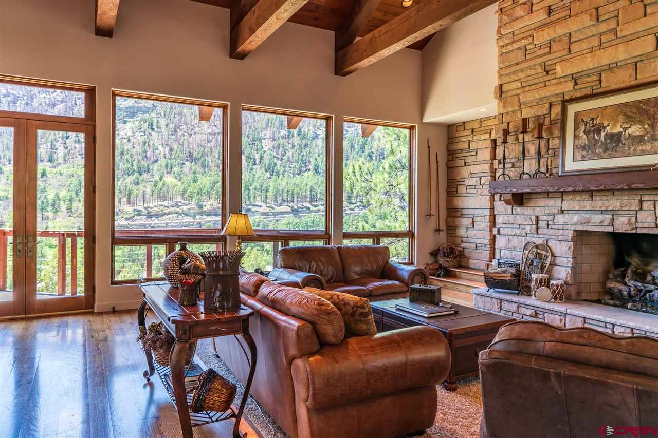 258 Goulding Creek Road Durango, CO 81301 - Photo 6 of 35 a living room with furniture a fireplace and floor to ceiling windows