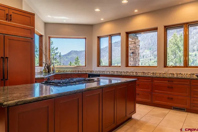 a kitchen with stainless steel appliances granite countertop a stove a sink and a microwave
