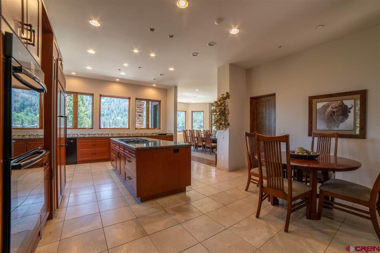 258 Goulding Creek Road Durango, CO 81301 - Photo 10 of 35 a kitchen with stainless steel appliances kitchen island granite countertop a sink and a refrigerator