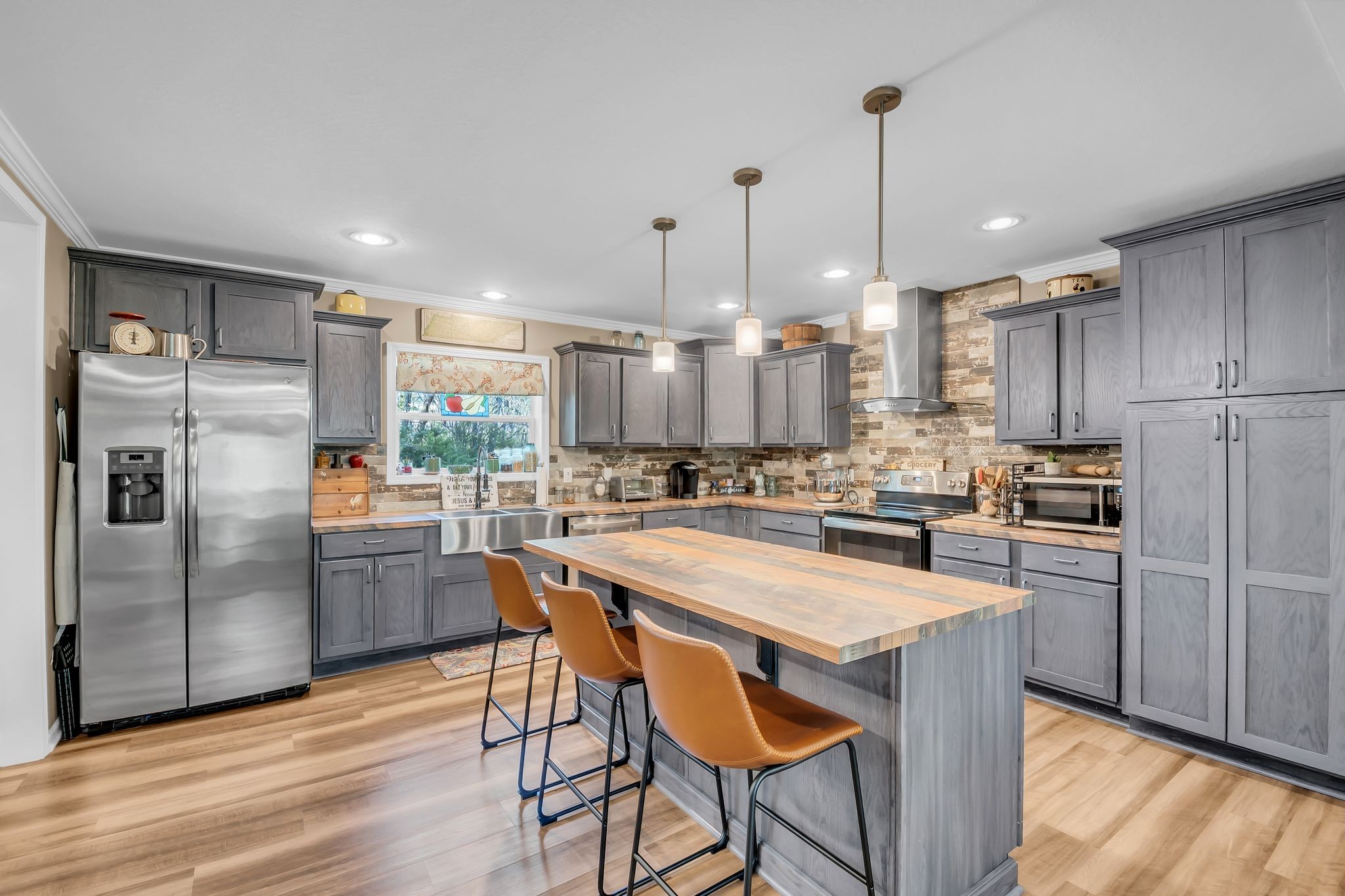 4241 Tanyard Hill Road Lynchburg, TN 37352 - Photo 11 of 50 a kitchen with kitchen island a refrigerator a stove a oven a sink a dining table and chairs with wooden floor