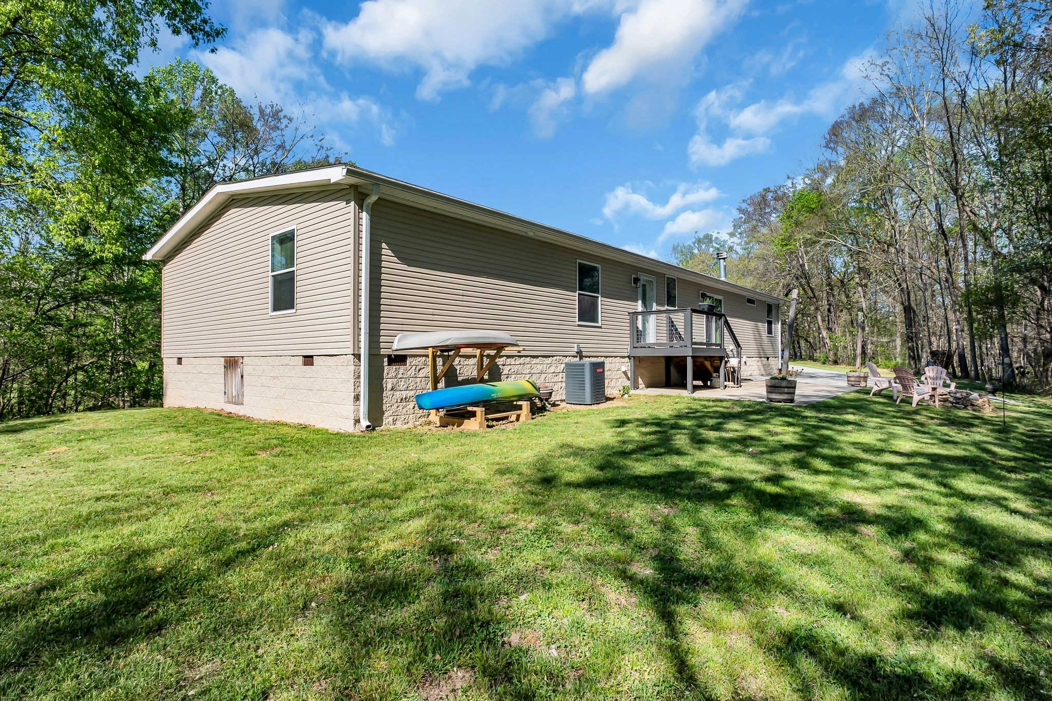 4241 Tanyard Hill Road Lynchburg, TN 37352 - Photo 32 of 50 a backyard of a house with table and chairs plants and large tree