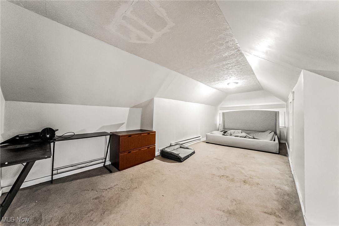 2014 Cook Avenue Cleveland, OH 44109 - Photo 22 of 37 Bonus room with a textured ceiling, vaulted ceiling, baseboard heating, and carpet