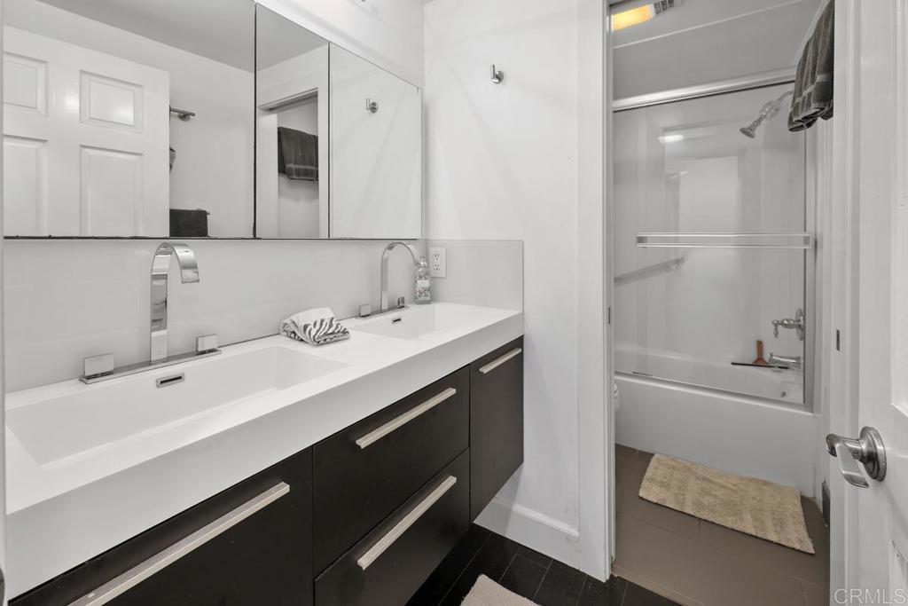 328 Shoemaker Court Solana Beach, CA 92075 - Photo 12 of 19 a bathroom with a double vanity sink a mirror and a bathtub