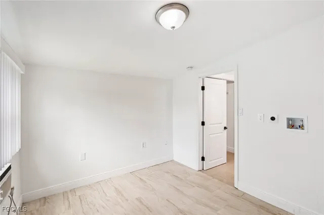 a view of a room with wooden floor and mirror