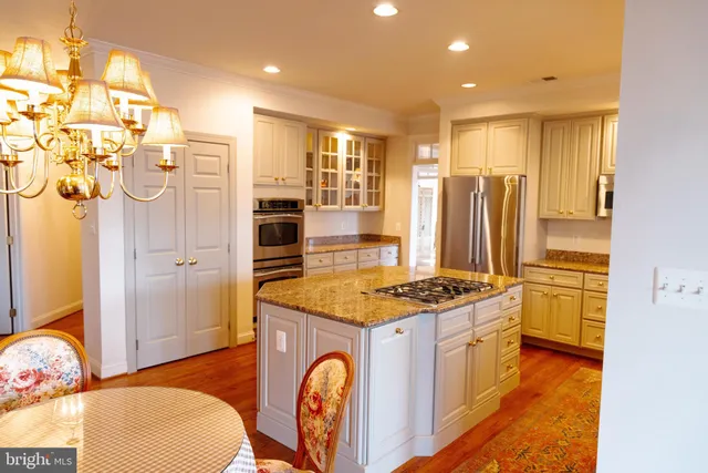 a kitchen with stainless steel appliances granite countertop a stove a sink and a refrigerator