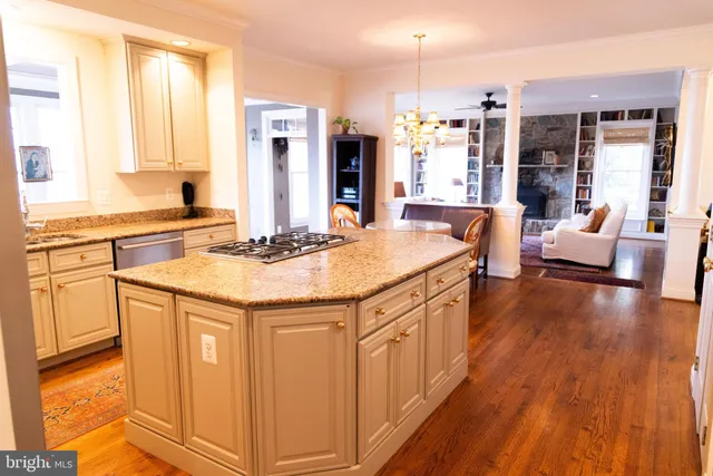a kitchen with stainless steel appliances granite countertop a sink stove and wooden floor