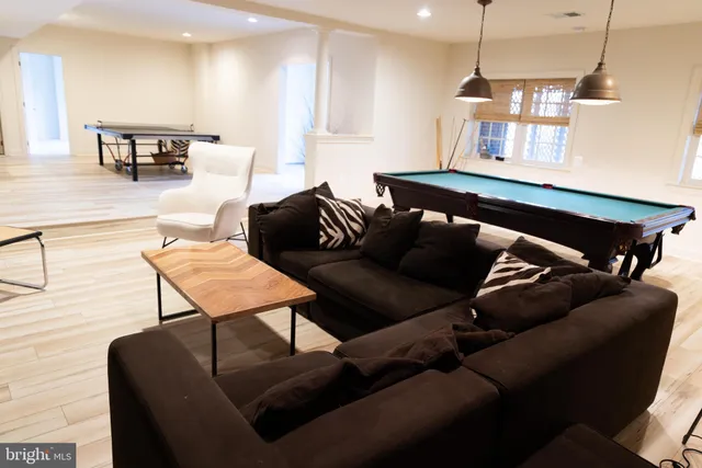 a view of a porch with wooden fence and large trees