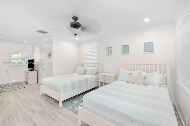 a bedroom with two beds and painting on the wall