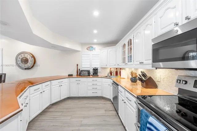 a large kitchen with stainless steel appliances granite countertop a stove and a sink