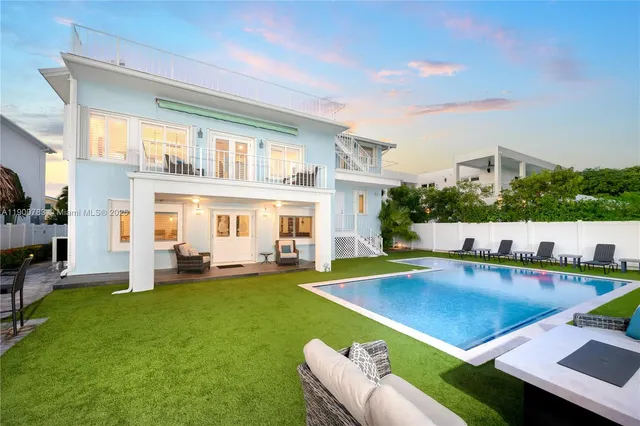 a view of a house with swimming pool and chairs
