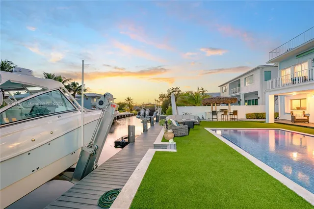 a view of a swimming pool with a chair and tables in the patio