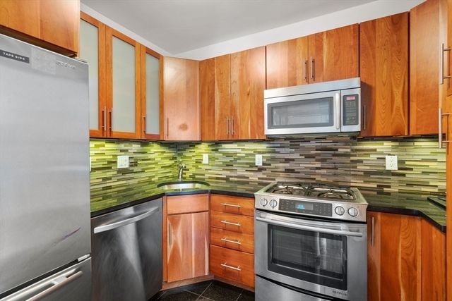 a kitchen with stainless steel appliances wooden cabinets and a stove top oven