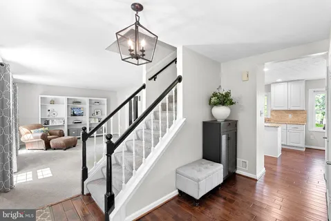 a living room with wooden floor and stairs