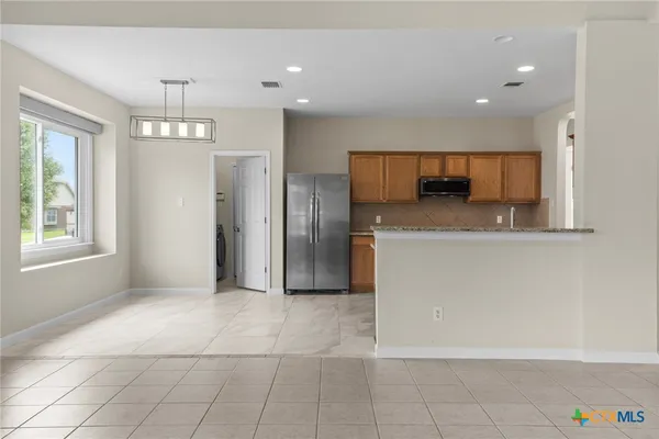 a kitchen with stainless steel appliances a refrigerator and a counter top space