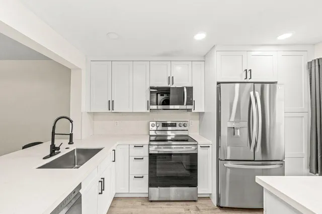 a kitchen with stainless steel appliances a refrigerator stove and microwave
