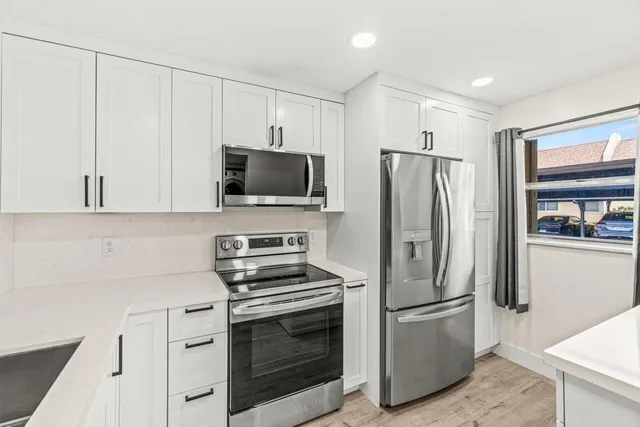 a kitchen with stainless steel appliances a refrigerator stove and microwave